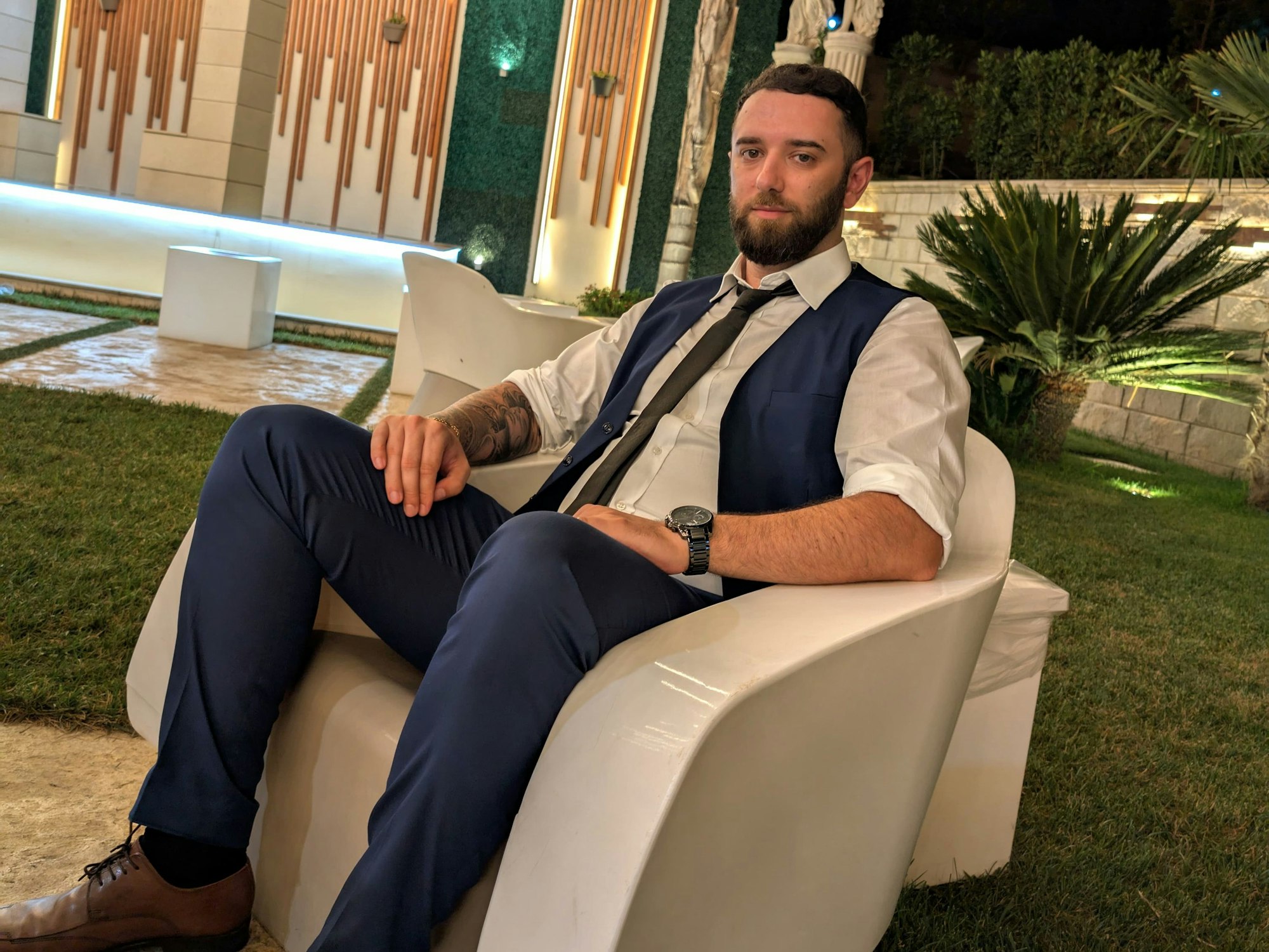 Giuseppe P. sitzt auf einem Stuhl im Garten.