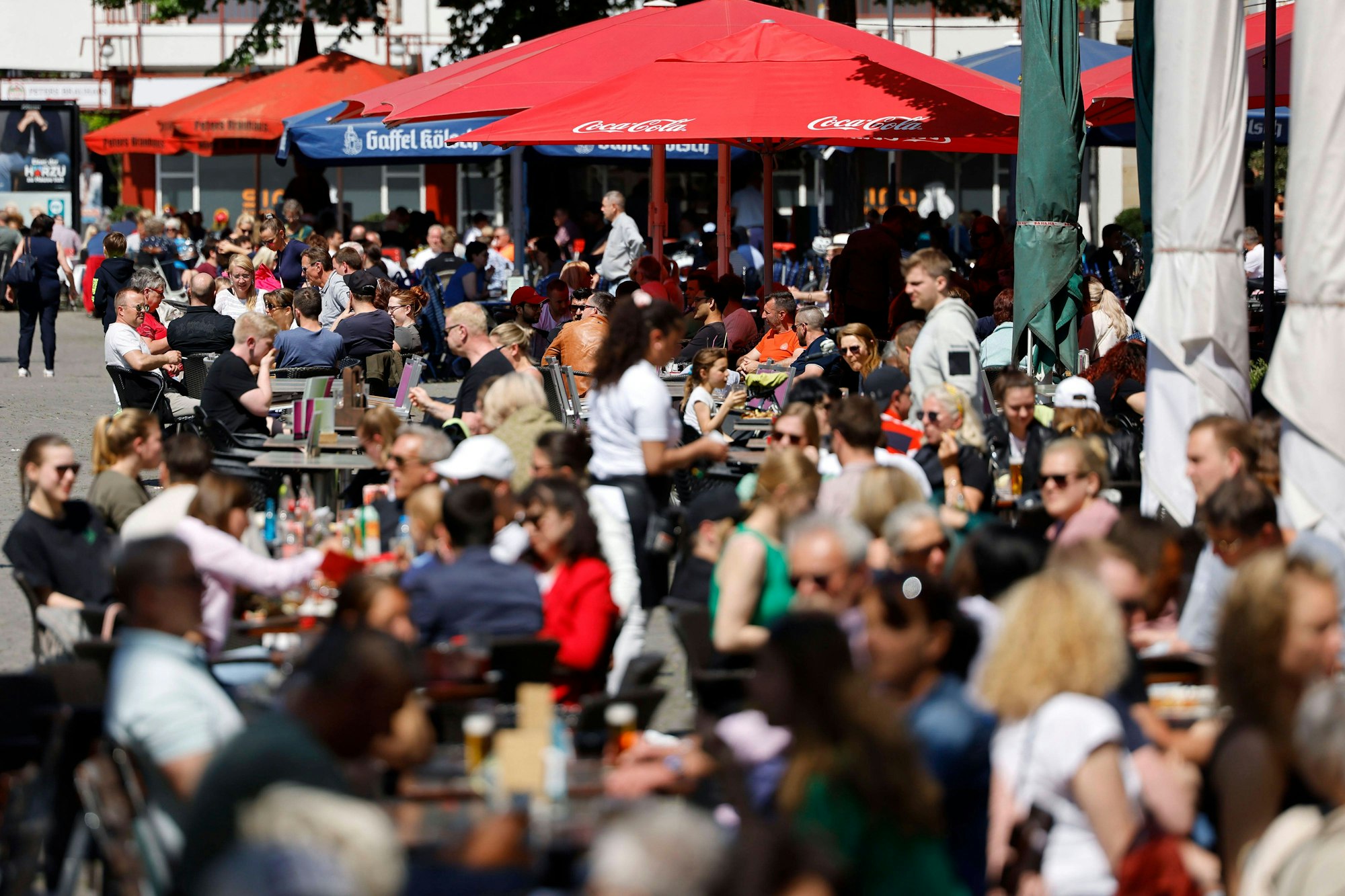 Gäste genießen die Sonne in der Außengastronomie der Bars und Lokale der Kölner Altstadt.