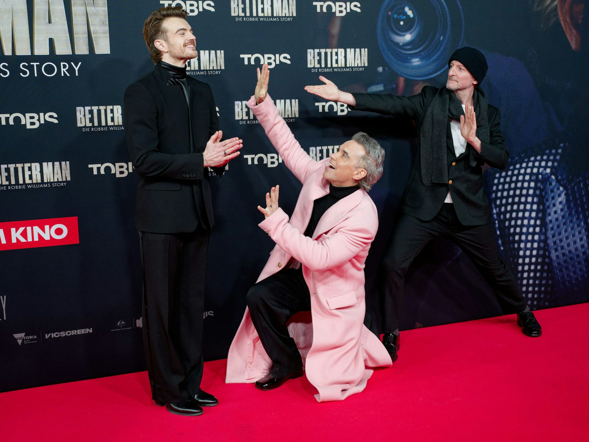 Schauspieler Jonno Davies (l), Sänger Robbie Williams (M) und Regisseur Michael Gracey (r) kommen zur Premiere des Films "Better Man - Die Robbie Williams Story".