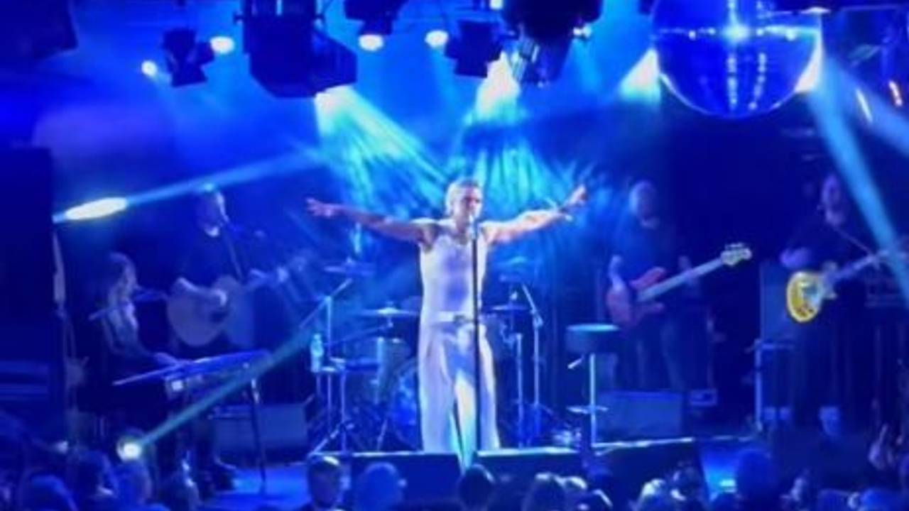 Robbie Williams auf der Bühne ganz in weiß bei einem geheimen Konzert in Köln.