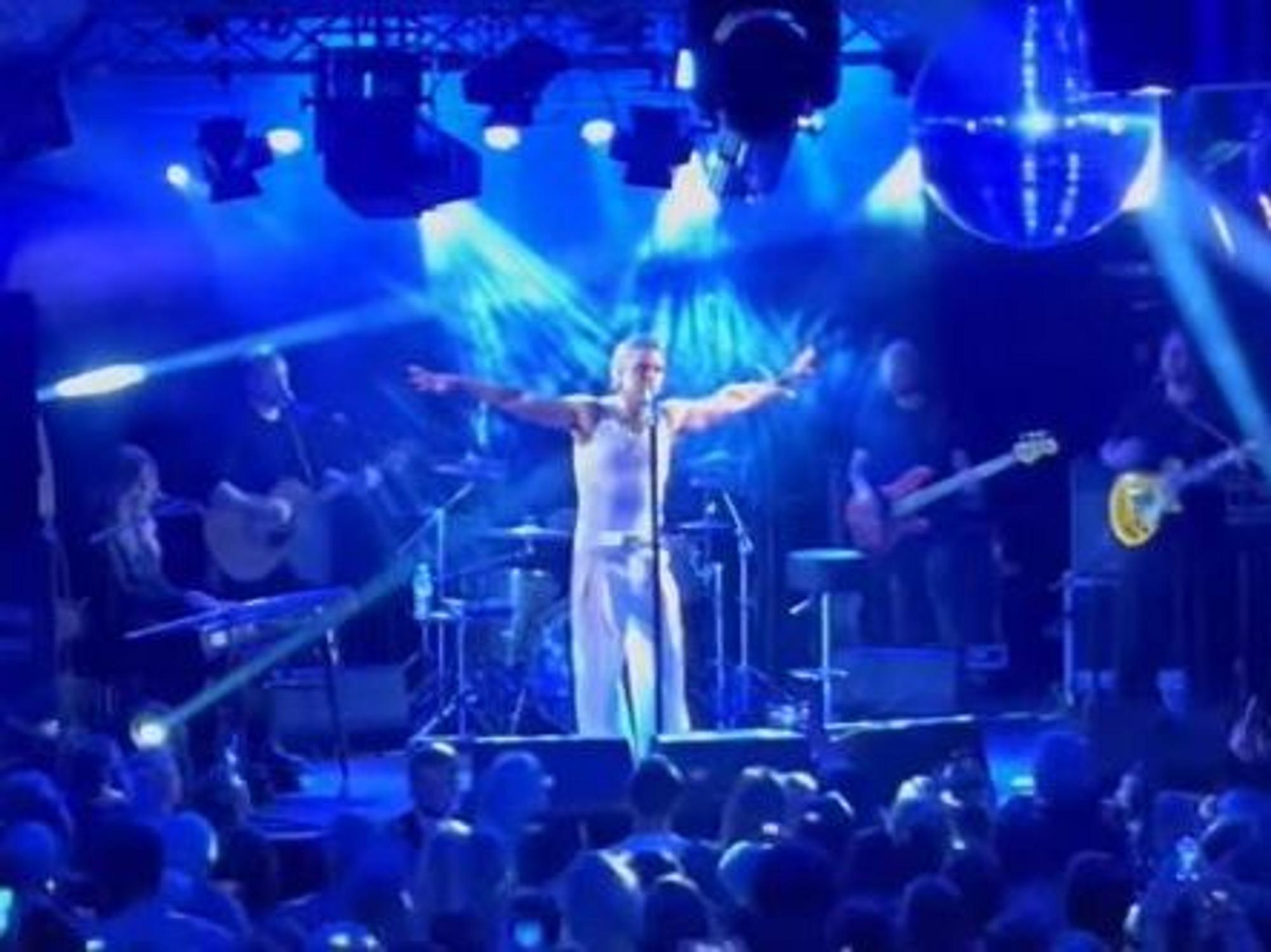 Robbie Williams auf der Bühne ganz in weiß bei einem geheimen Konzert in Köln.
