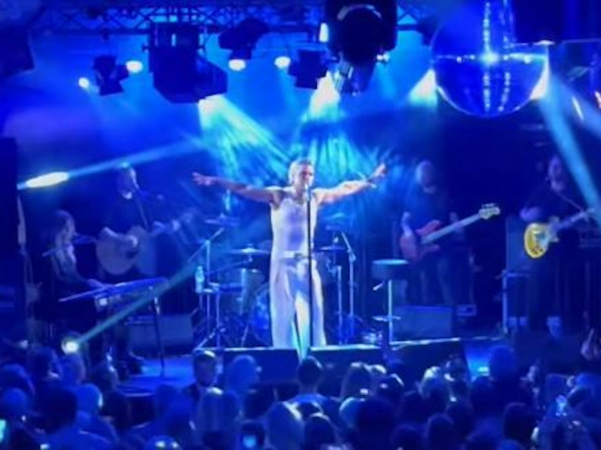 Robbie Williams auf der Bühne ganz in weiß bei einem geheimen Konzert in Köln.