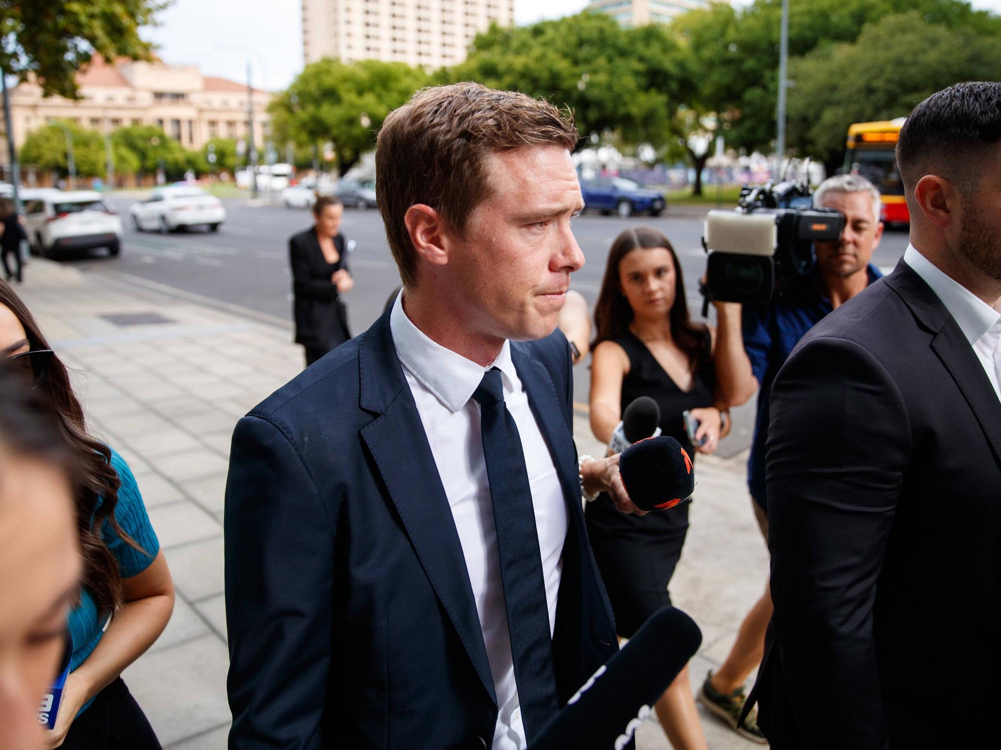 Rohan Dennis kommt am Gericht in Adelaide an und wird von Medien umzingelt.