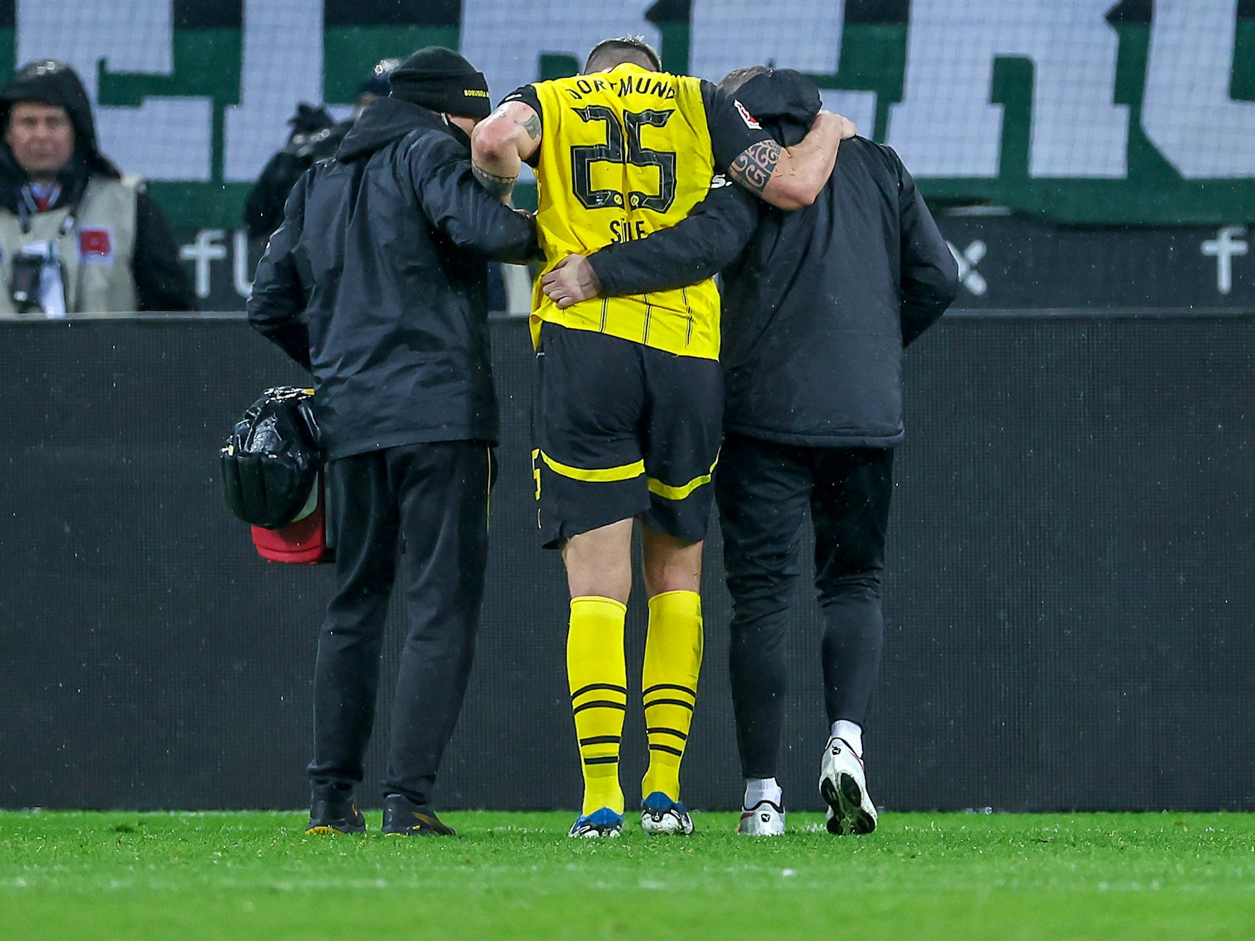 Niklas Süle verlässt gestützt von zwei Betreuern das Spielfeld.