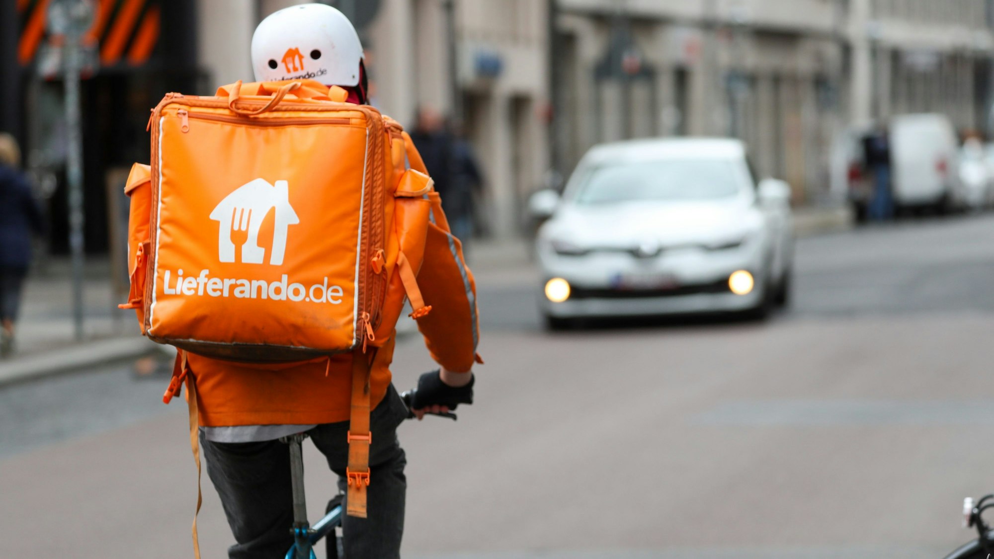Ein Fahrradbote vom Lieferdienst Lieferando fährt durch die Leipziger Innenstadt.
