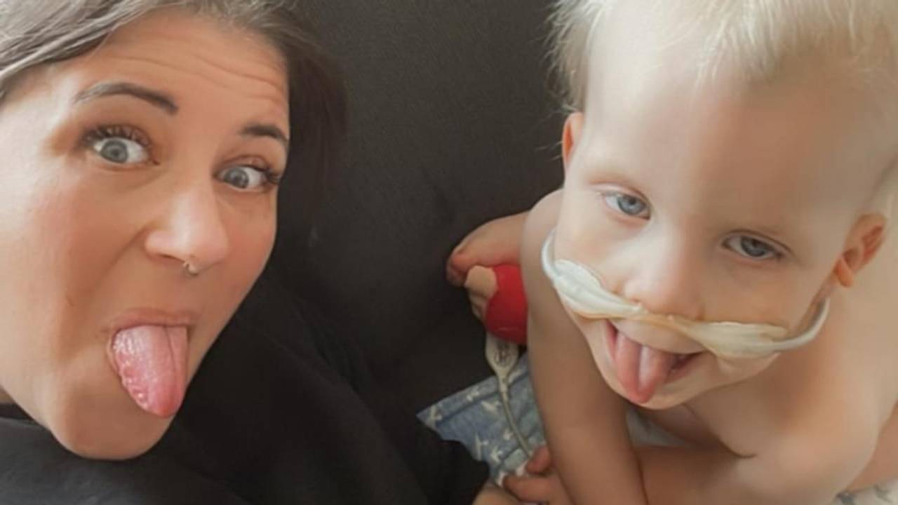 Eine Frau und ein Junge strecken für ein Foto ihre Zungen heraus.