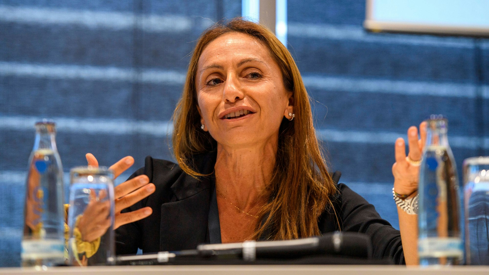 Alice Mascia gestikuliert während einer Pressekonferenz.