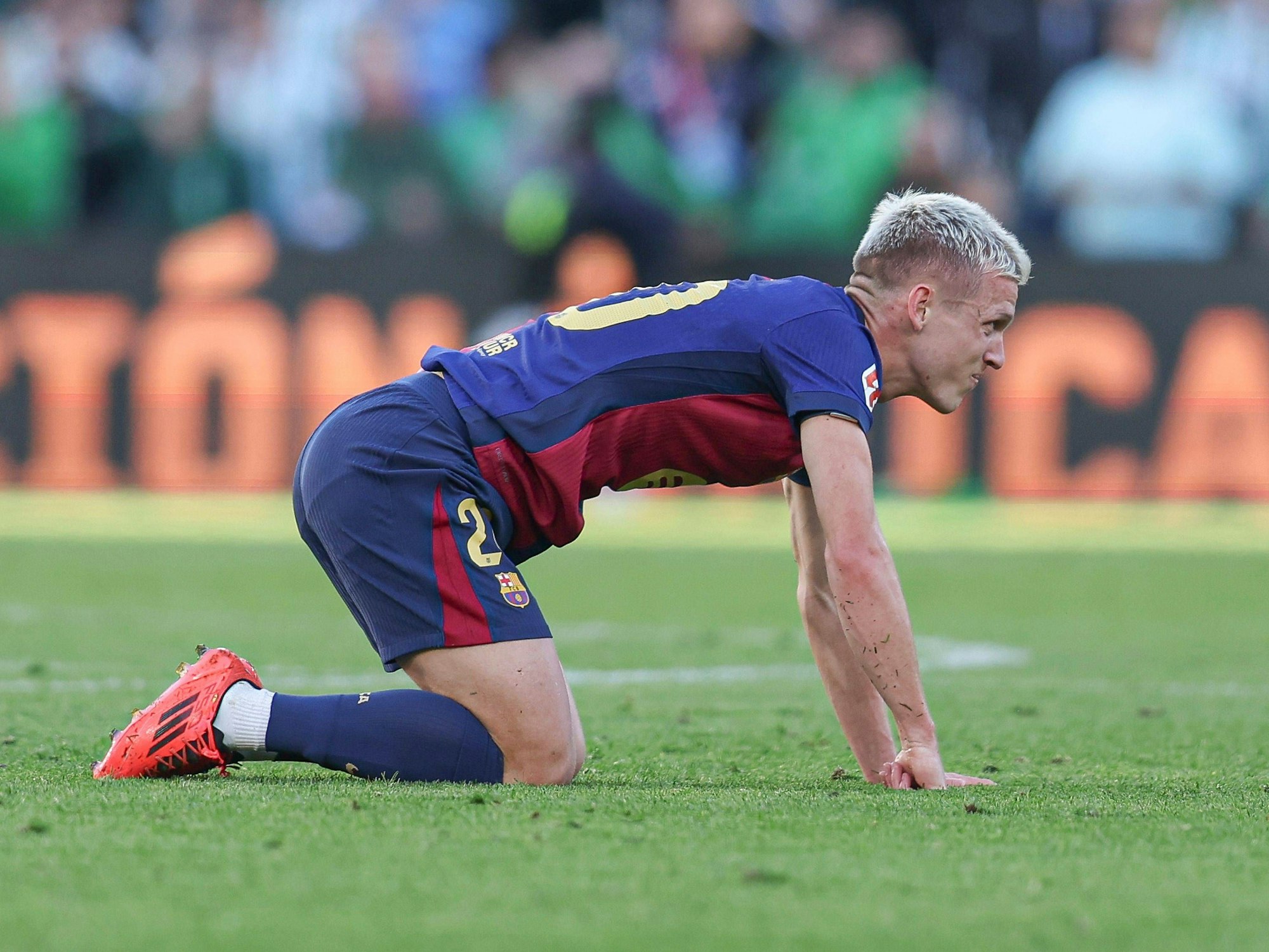 Dani Olmo kniet enttäuscht auf dem Rasen.