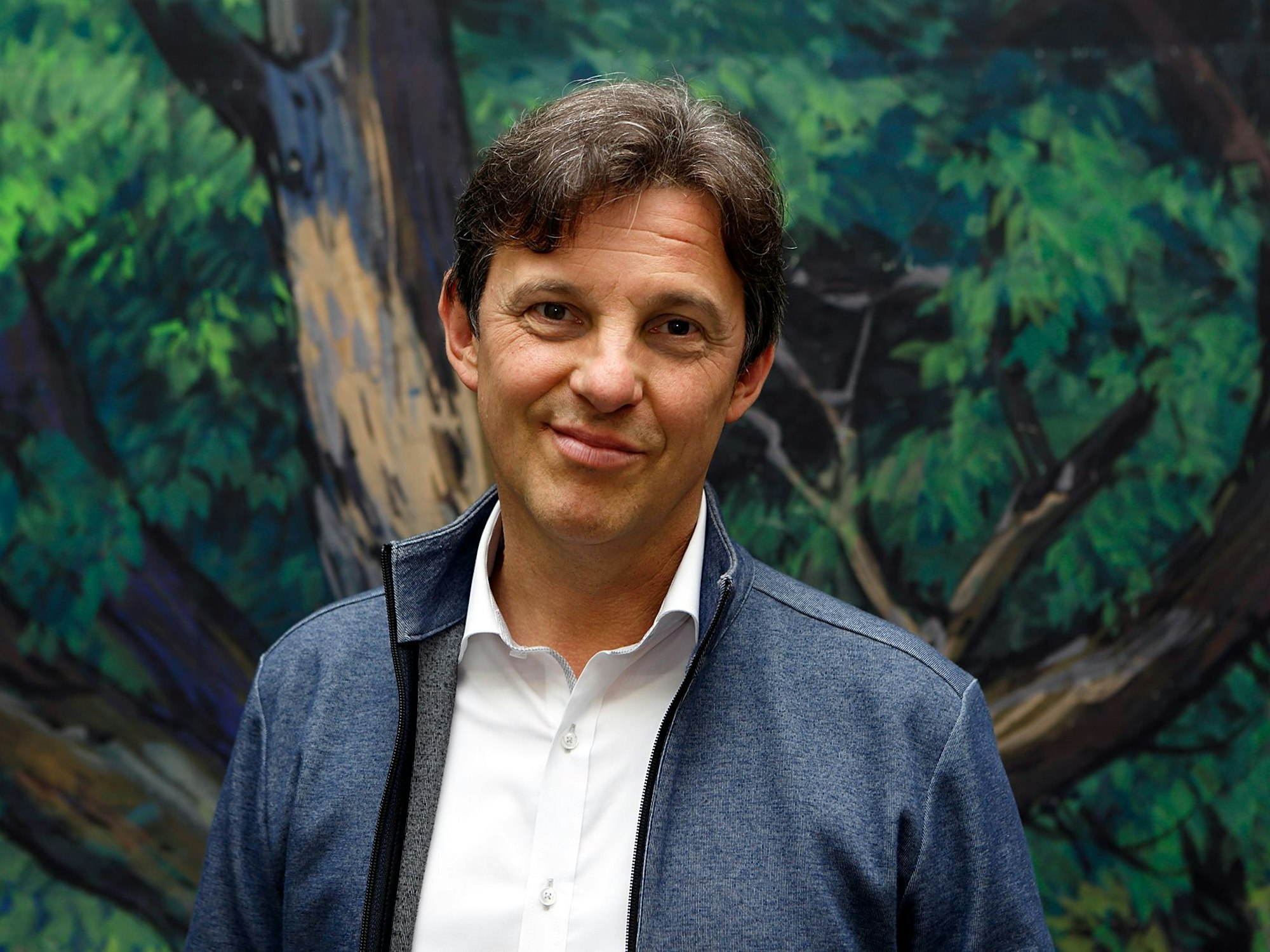 Puppenspieler Charly Kemmerling schaut mit einem Grinsen in die Kamera.