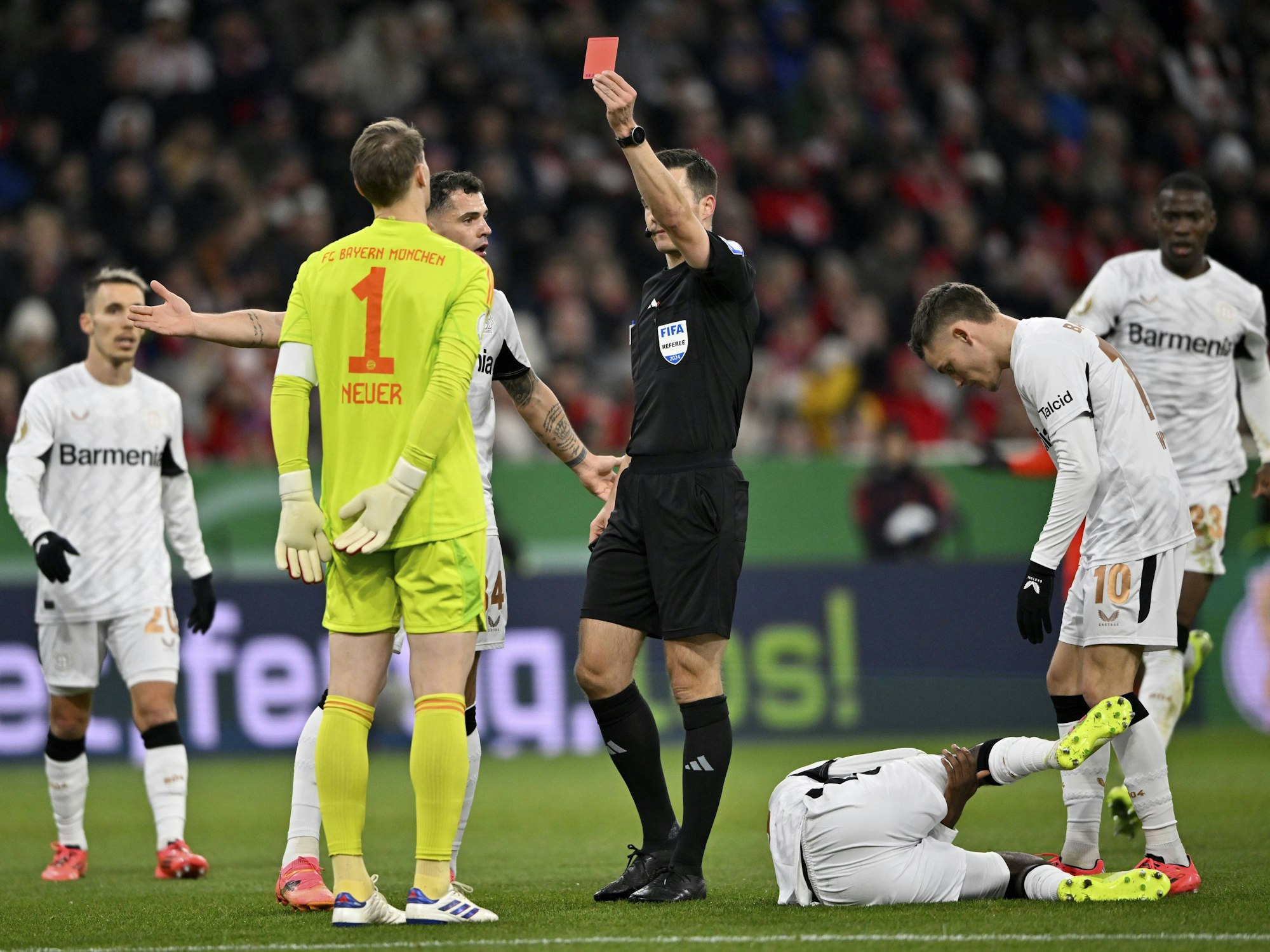 Schiedsrichter Harm Osmers (M.) zeigt Torwart Manuel Neuer die Rote Karte beim Spiel gegen Bayer Leverkusen