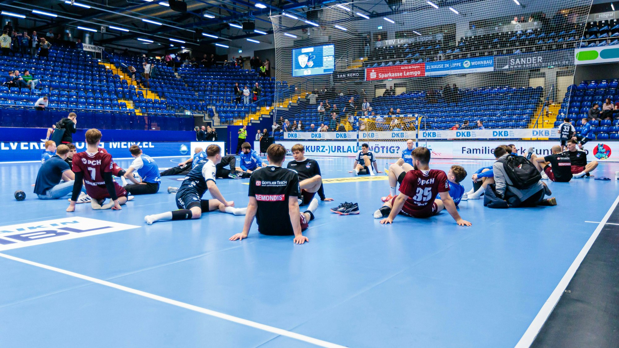 Die Mannschaften der TBV Lemgo und vom VfL Potsdam warten in der Halle nach einer Spielunterbrechung am Sonntag (15. Dezember 2024) auf das weitere Vorgehen.