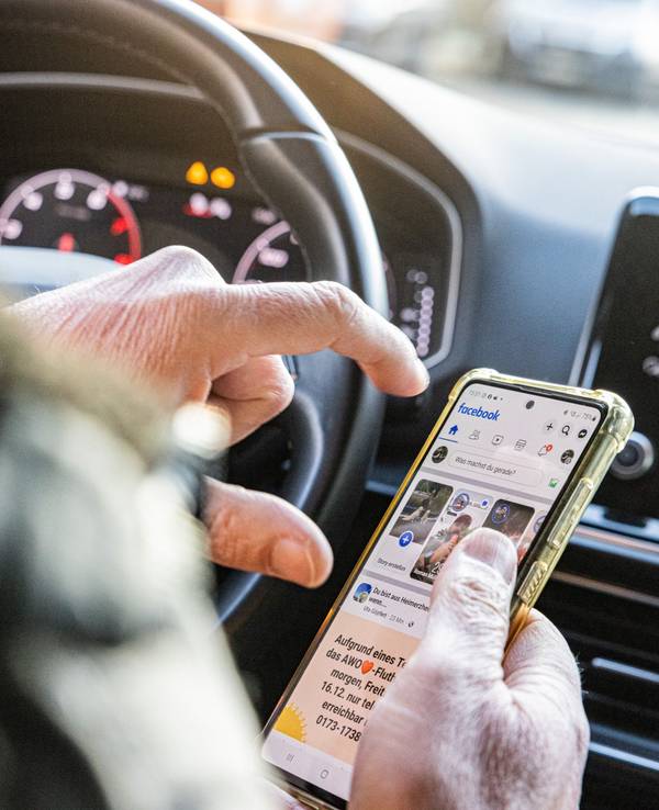 Person wird durch ihre Smartphone-Nutzung am Steuer abgelenkt.