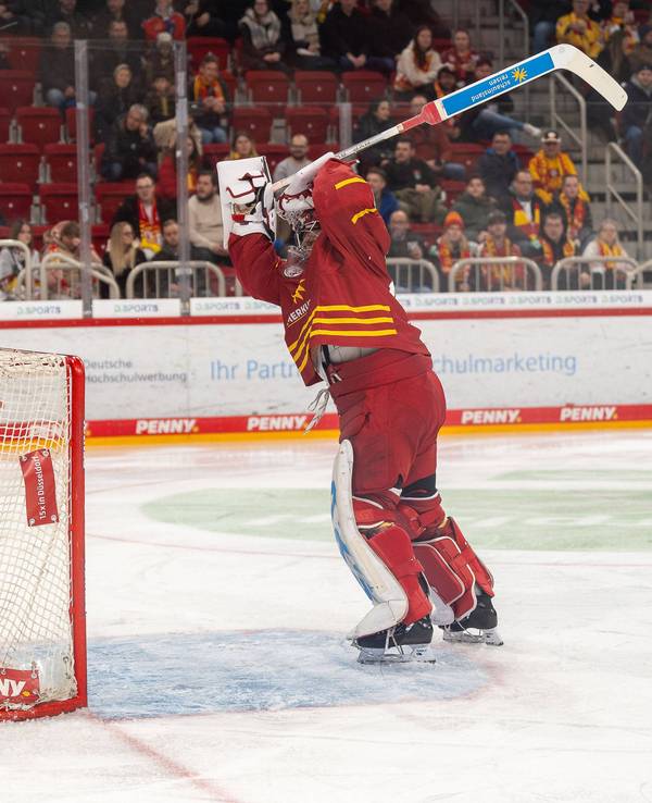 Goalie Henrik Haukeland von der Düsseldorfer EG drischt mit seinem Schläger vor Wut auf sein Tor ein.