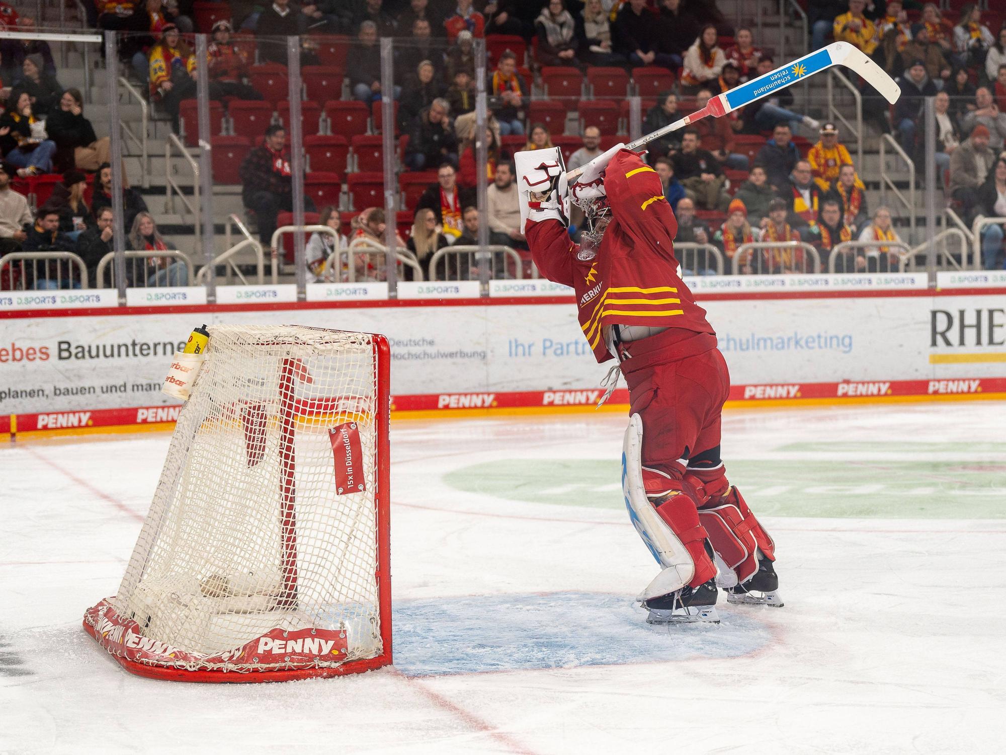 Goalie Henrik Haukeland von der Düsseldorfer EG drischt mit seinem Schläger vor Wut auf sein Tor ein.