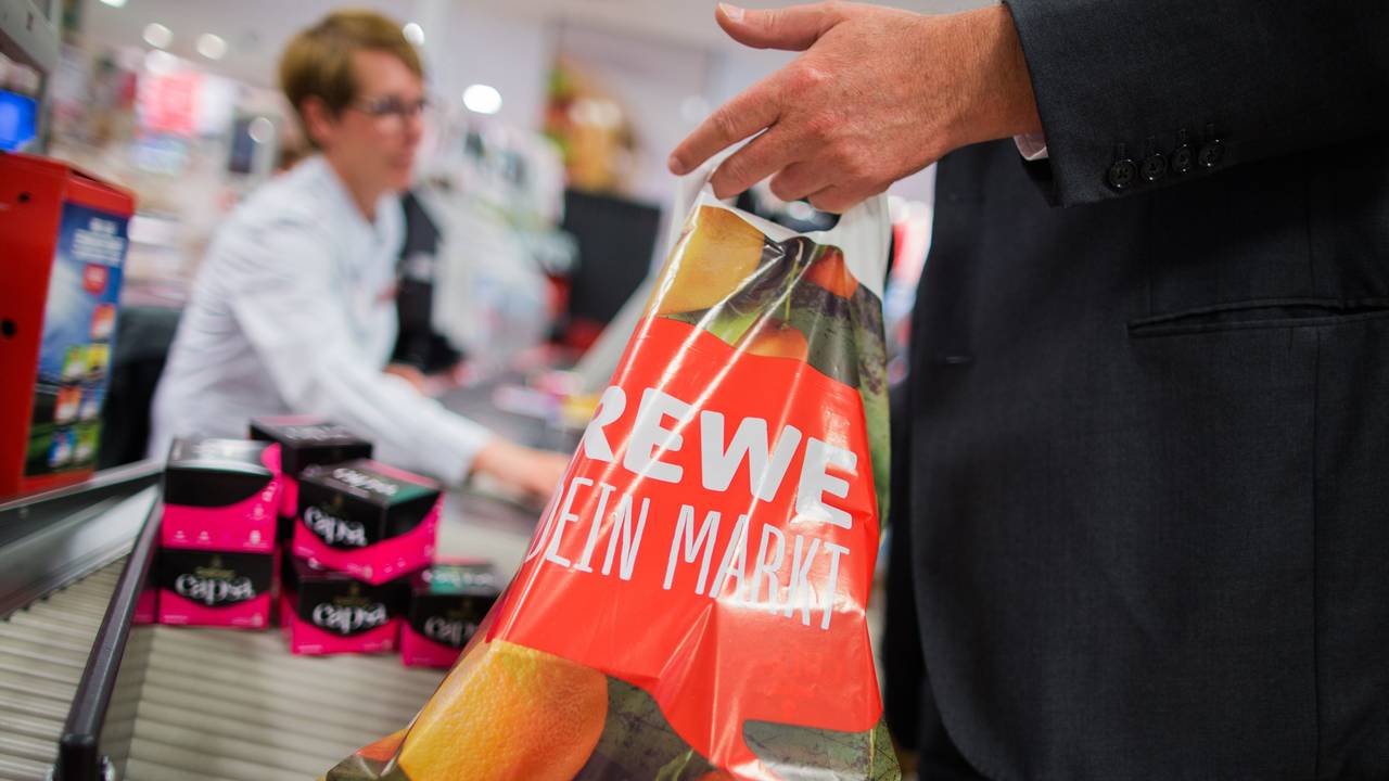 Ein Kunde packt am 31.05.2016 an der Kasse eines Rewe-Marktes in Düsseldorf (Nordrhein-Westfalen) seine Einkäufe in eine Tragetasche aus Plastik. Die Rewe Group möchte eine Reduzierung von Plastikmüll erreichen und verzichtet in Zukunft in ihren Märkten auf Plastiktüten. Foto: Rolf Vennenbernd/dpa ++ +++ dpa-Bildfunk +++