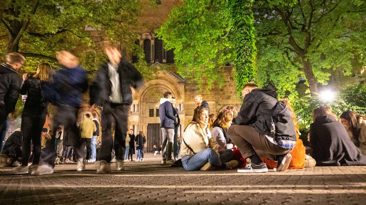Feiernde sitzen am Brüsseler Platz in Köln auf dem Boden oder feiern gemeinsam die Mai-Nacht 2022.