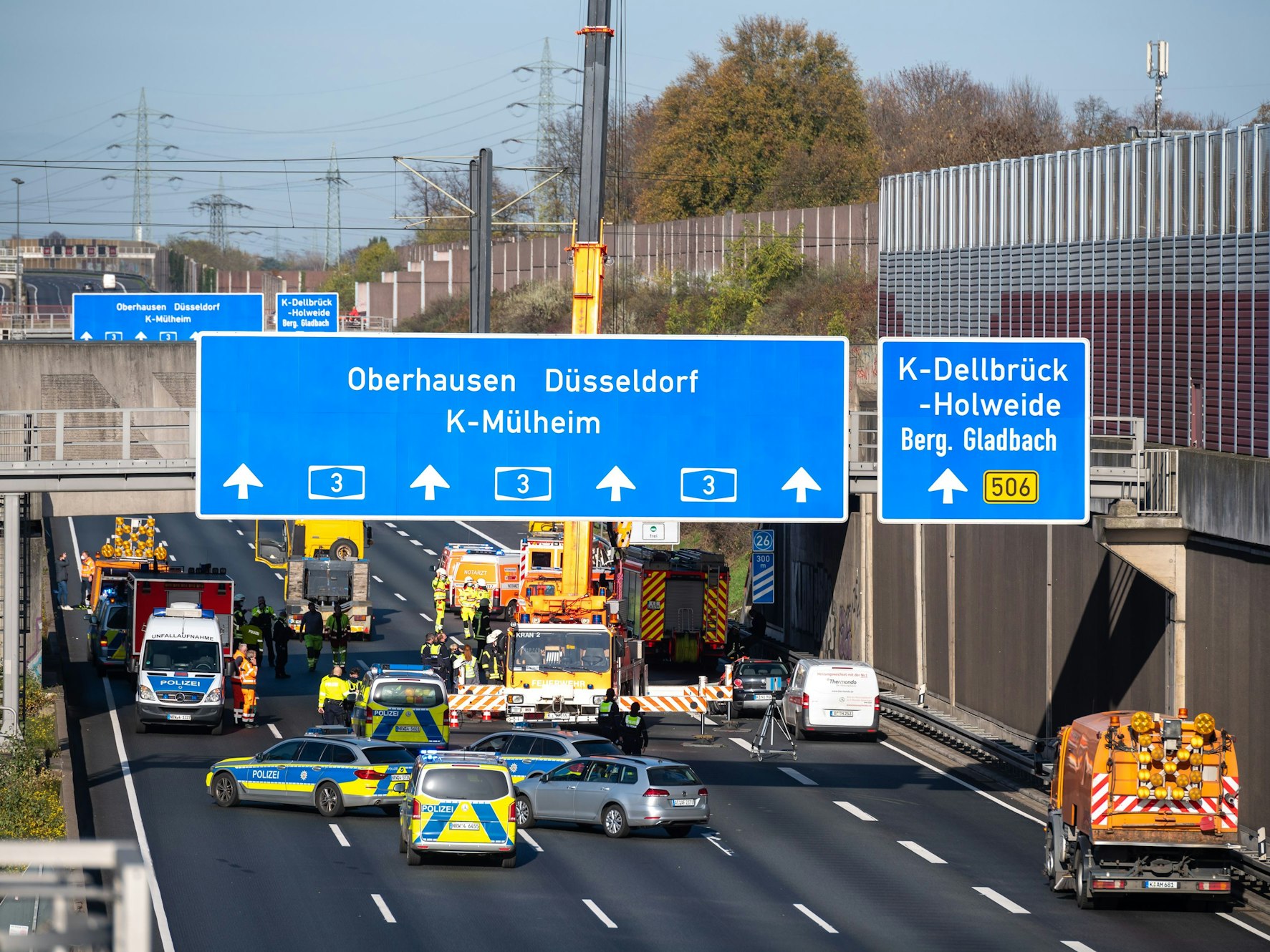 Polizei und Rettungsdienst stehen auf der A3 in Köln nach einem Unfall.