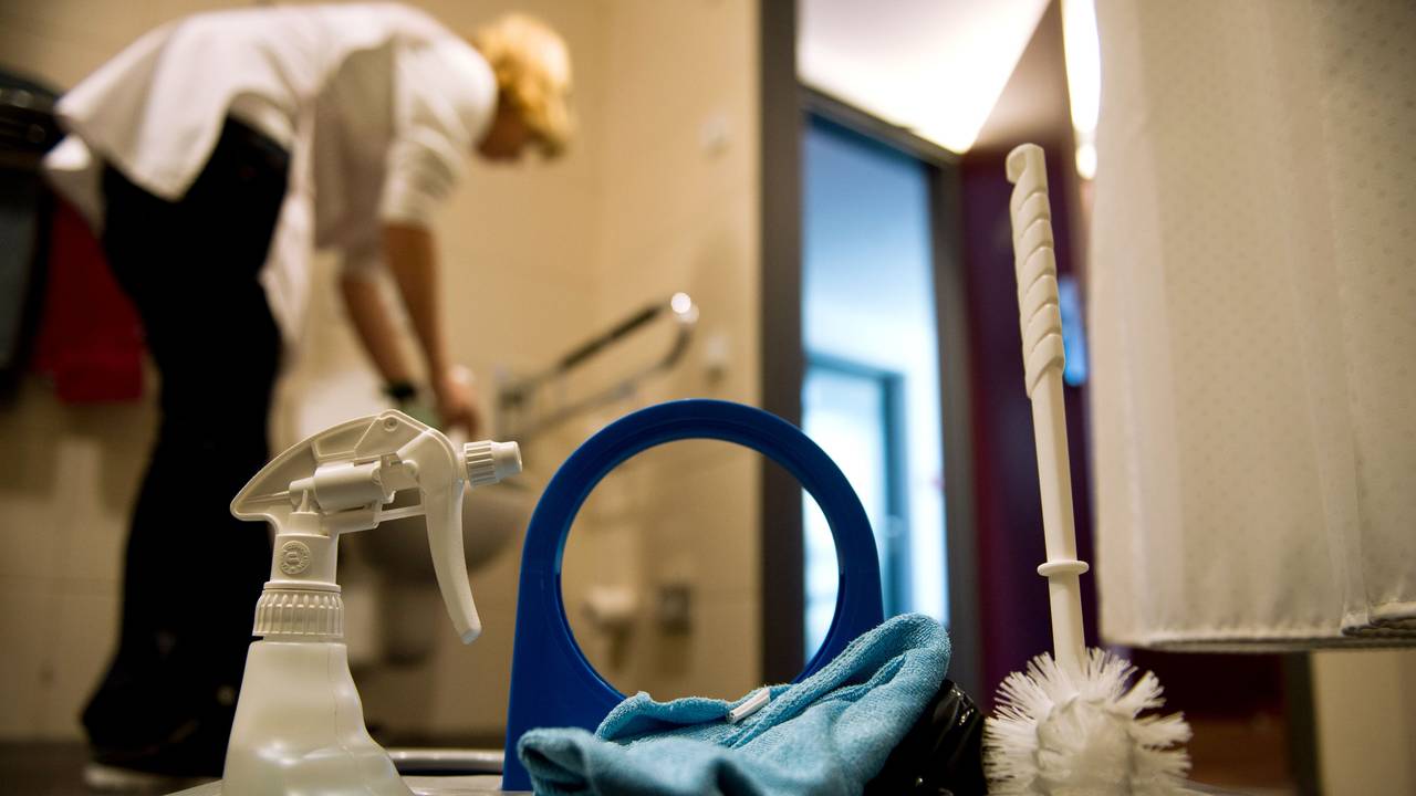 Ein Zimmermädchen reinigt eine Toilette in einem Zimmer in einem Hotel.
