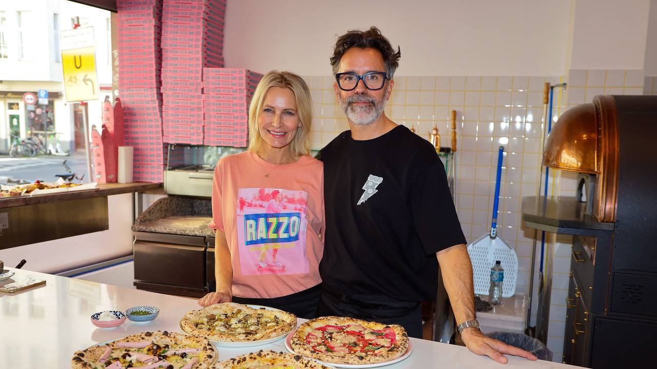 Verena Malta und Ingo Noack stehen an der Theke ihrer Pizzeria, vor ihnen einige vegane Pizzen.