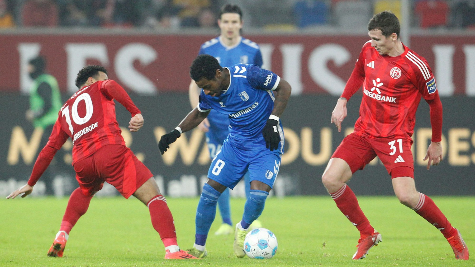 Die Düsseldorfer Myron van Brederode (l) und Marcel Sobottka und der Magdeburger Bryan Teixeira (M) kämpfen um den Ball.