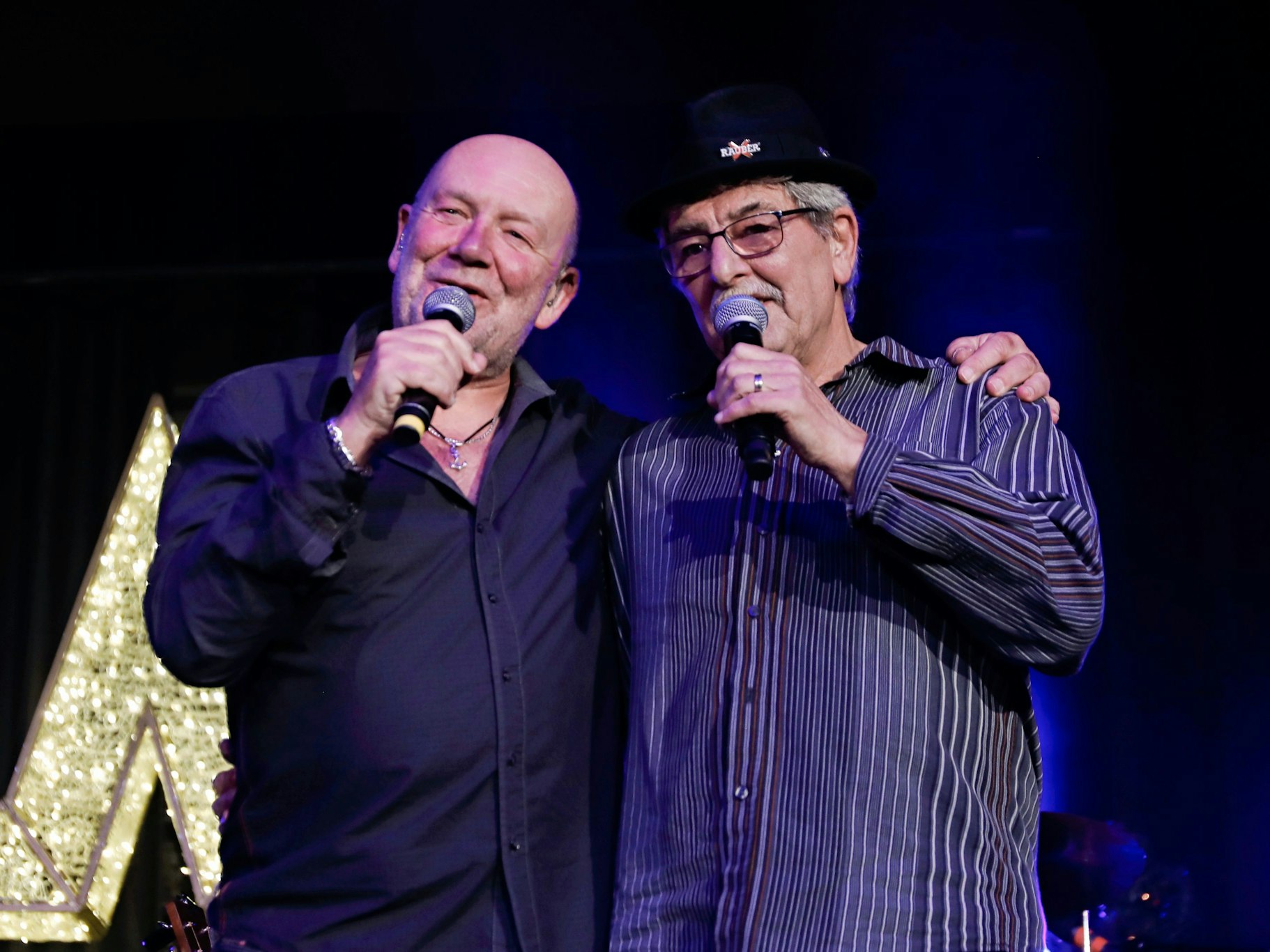 Zwei Männer singen auf einer Bühne.