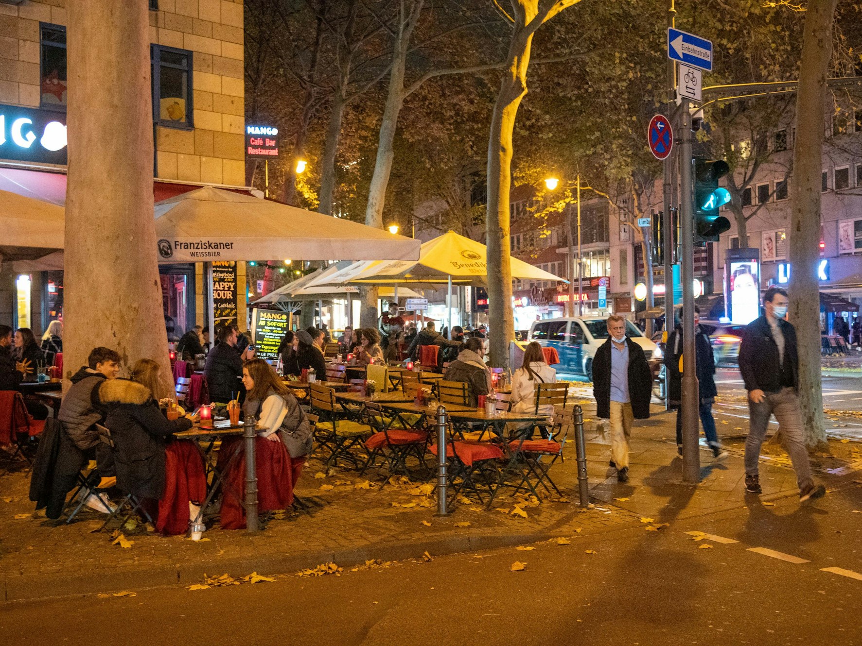 Menschen sitzen im Außenbereich eines Restaurants auf dem Hohenzollernring in Köln.