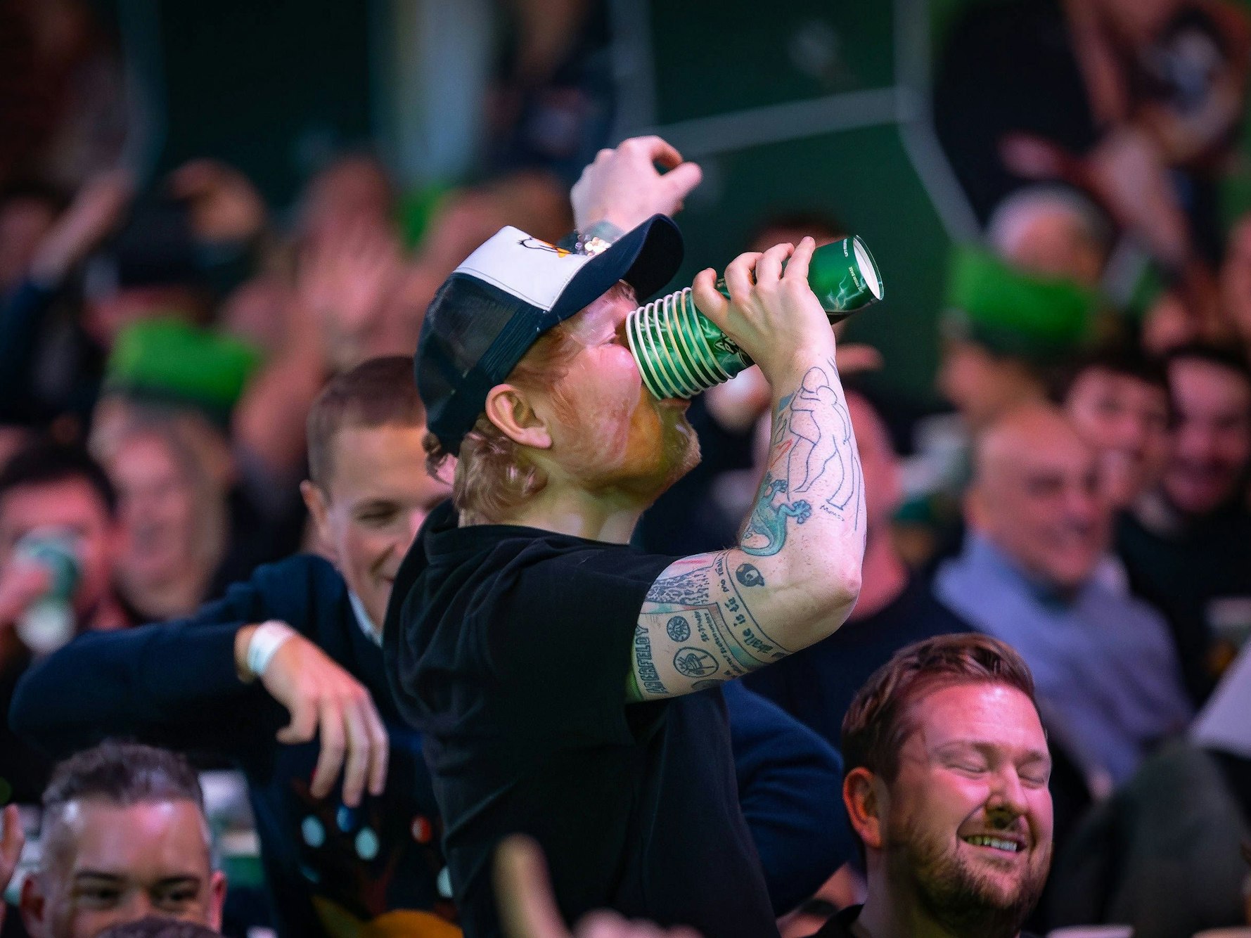 Ed Sheeran trinkt bei der Darts-WM Bier.