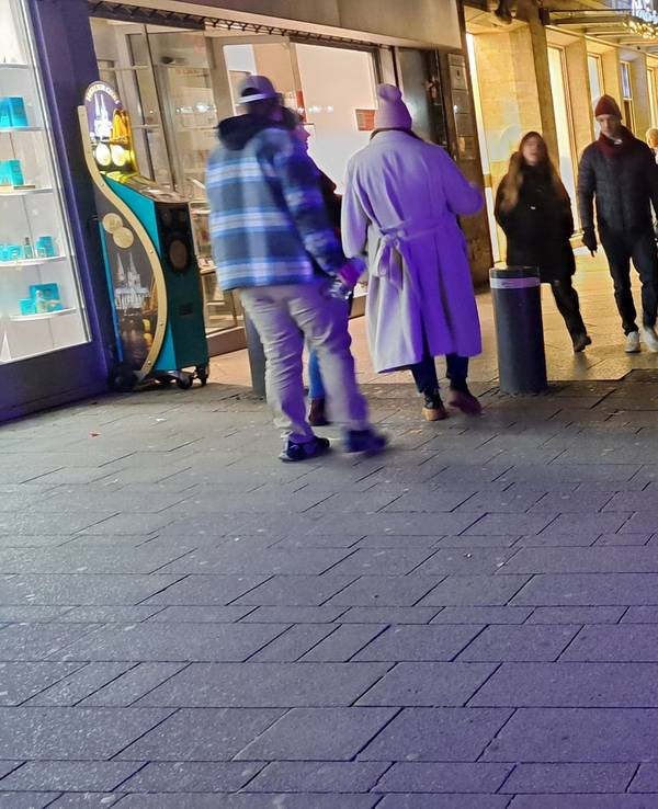 Menschen gehen am Wallrafplatz in Köln in Richtung Dom und Weihnachtsmarkt.