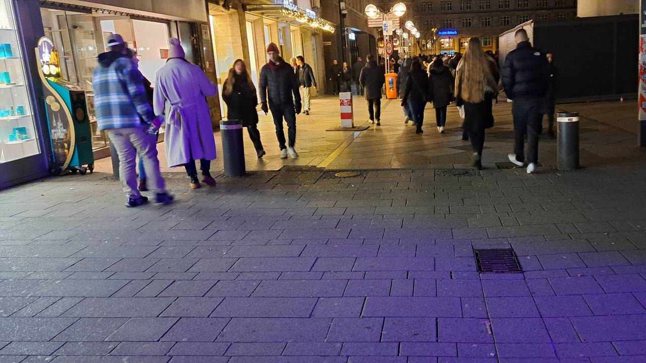 Menschen gehen am Wallrafplatz in Köln in Richtung Dom und Weihnachtsmarkt.