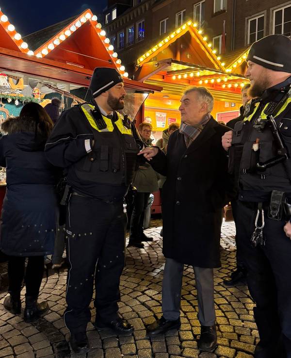 NRW-Innenminister Herbert Reul (CDU) im Gespräch mit zwei Polizisten am Freitag (20. Dezember) vor den Ständen eines Weihnachtsmarkts in Düsseldorf. Nach dem Anschlag von Magdeburg bleiben die Vorkehrungen für die Weihnachtsmärkte in Nordrhein-Westfalen zunächst unverändert.