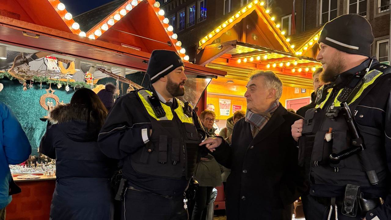 NRW-Innenminister Herbert Reul (CDU) im Gespräch mit zwei Polizisten am Freitag (20. Dezember) vor den Ständen eines Weihnachtsmarkts in Düsseldorf. Nach dem Anschlag von Magdeburg bleiben die Vorkehrungen für die Weihnachtsmärkte in Nordrhein-Westfalen zunächst unverändert.