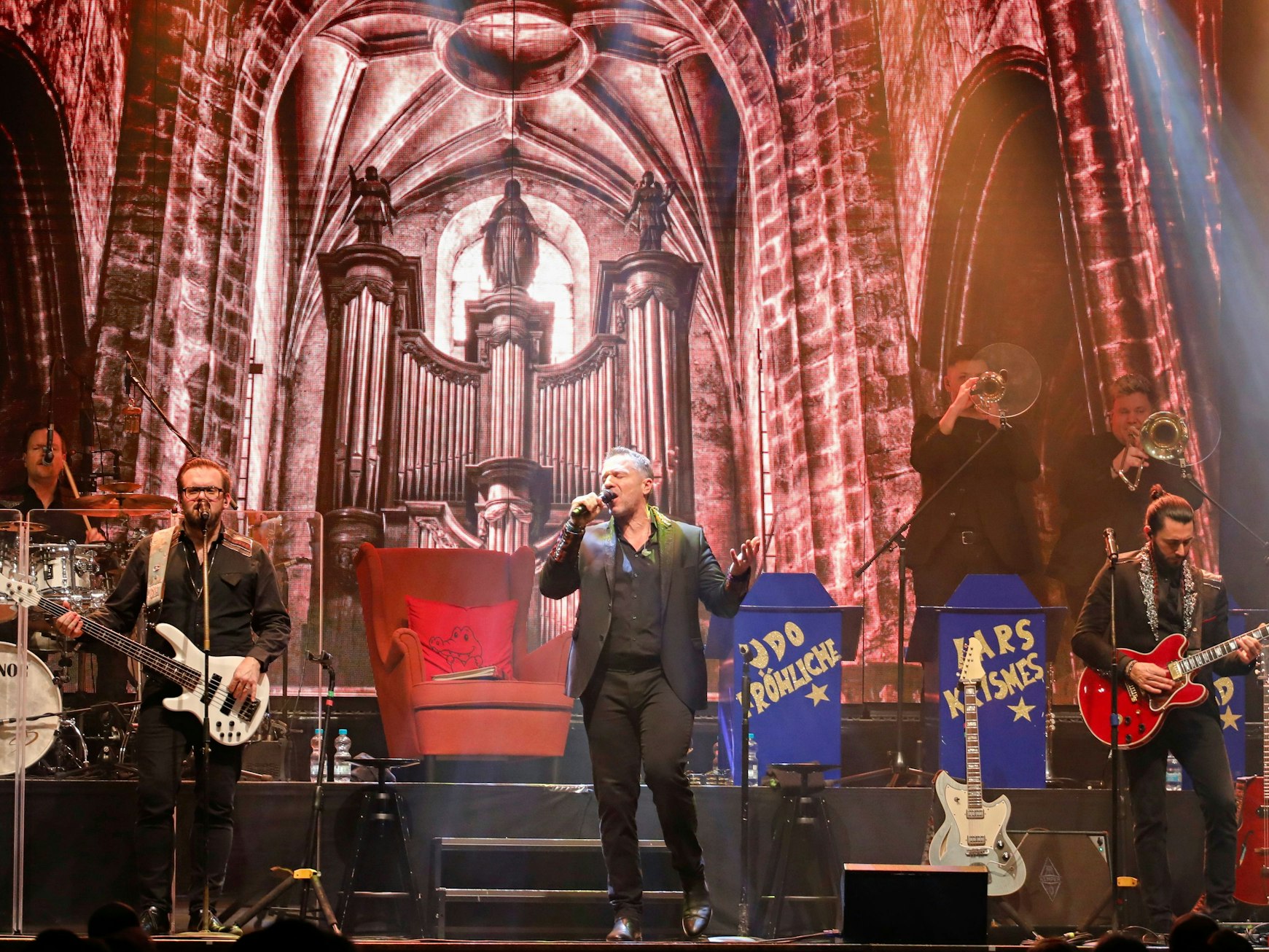 Eine Band steht bei einem Konzert auf einer Bühne.