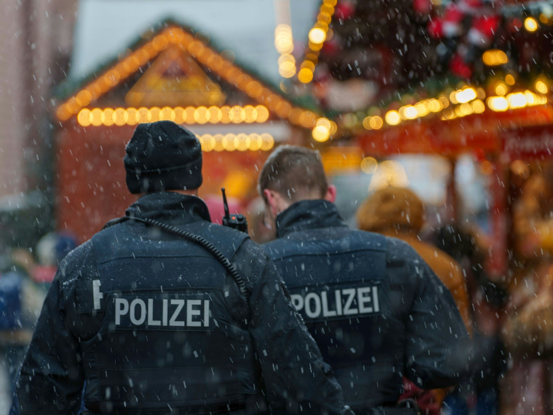 Zwei Polizisten gehen Streife auf dem Weihnachtsmarkt. (