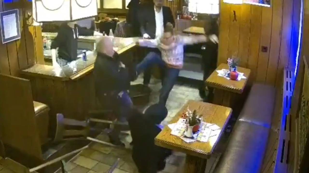 Ein Mann tritt in einer Kneipe nach einem anderen Mann.