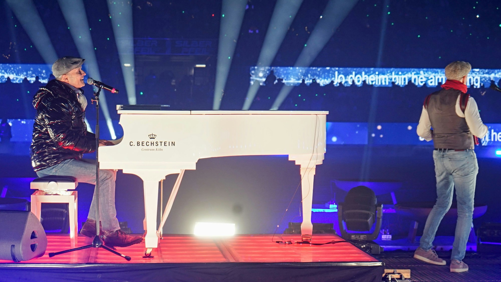 Frank Reudenbach sitzt am weißen Klavier und singt ein Lied.