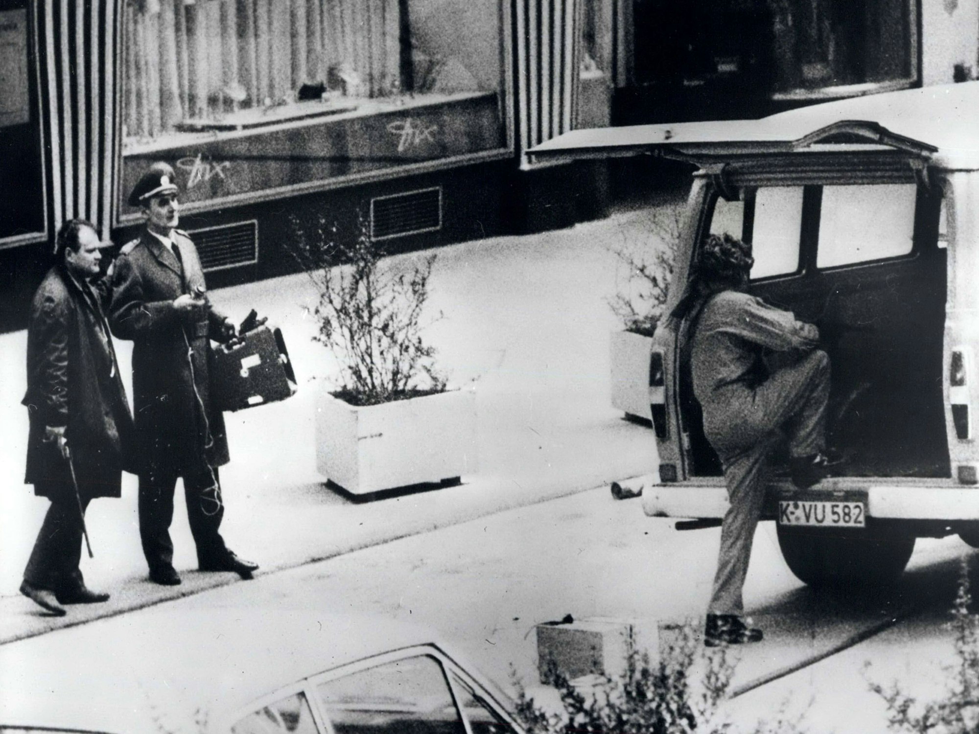 Bandenboss Kurt Vicenik (l.) steht mit einem sogenannten Revolvergewehr bewaffnet vor der Deutschen Bank in Köln. Neben ihm steht Schutzpolizei-Oberrat Hans Krauss.