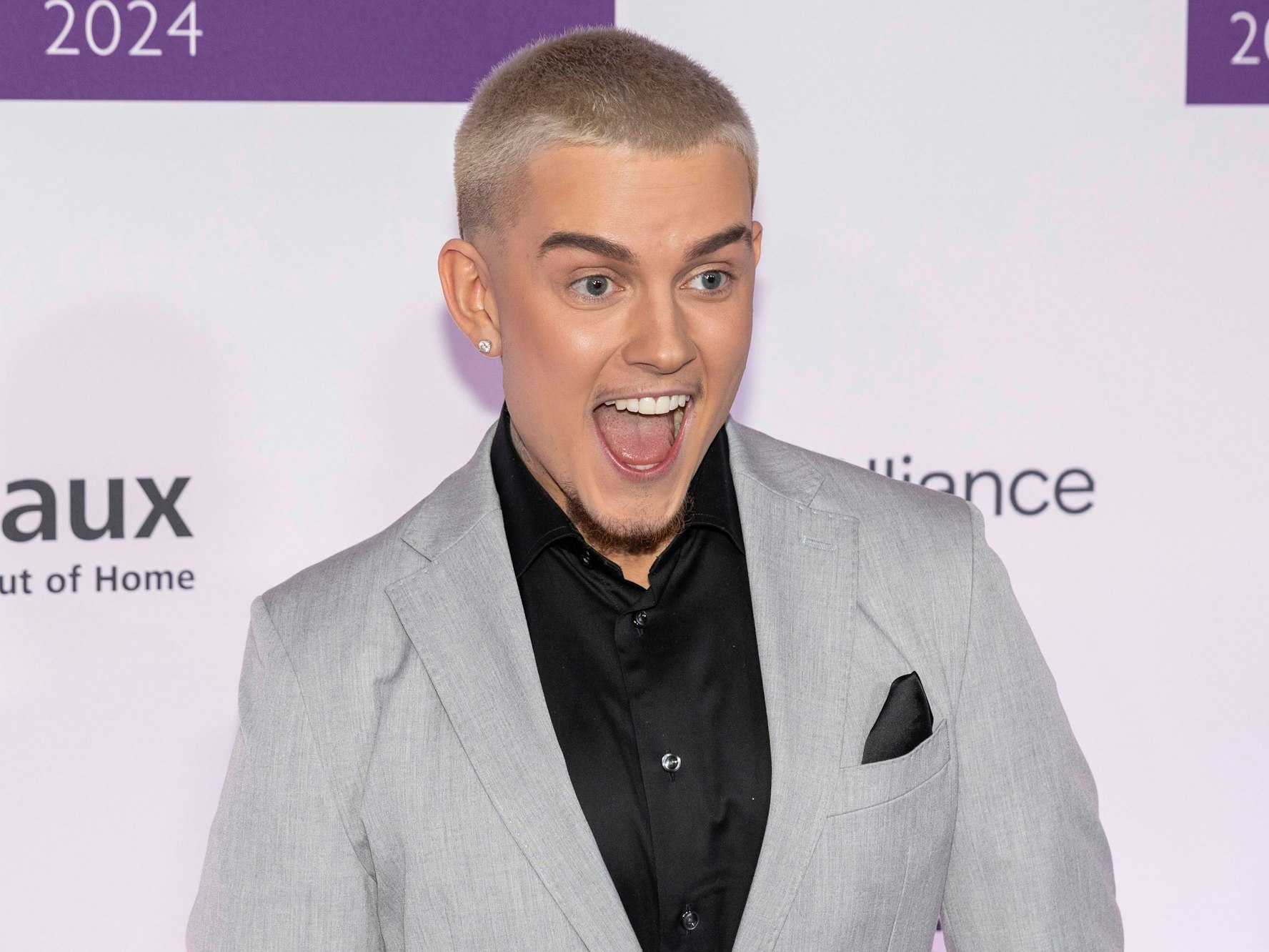 Influencer Twenty4Tim lacht in die Kamera.