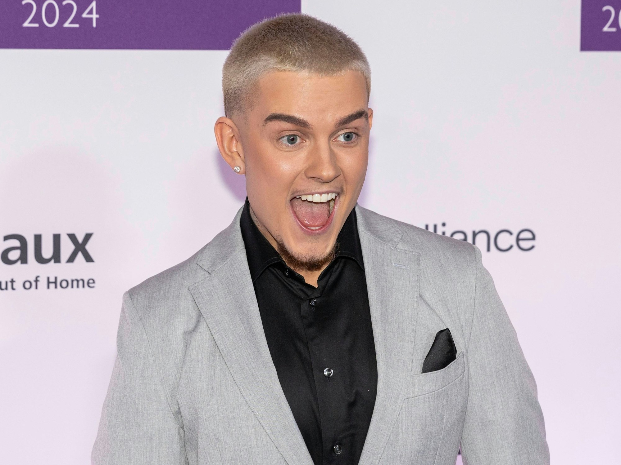 Influencer Twenty4Tim lacht in die Kamera.