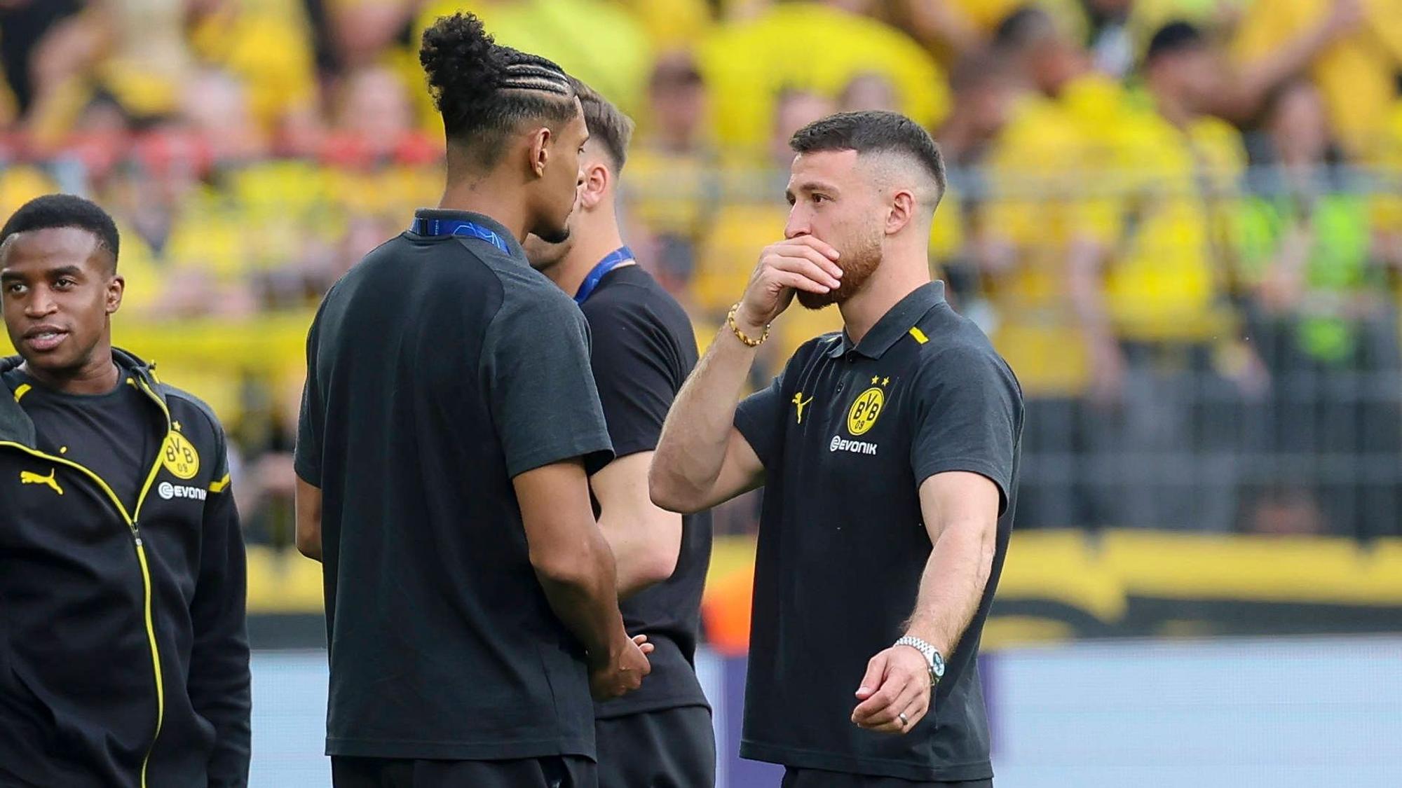 Sébastien Haller und Salih Özcan unterhalten sich bei der Platzbegehung, im Hintergrund steht Youssoufa Moukoko.