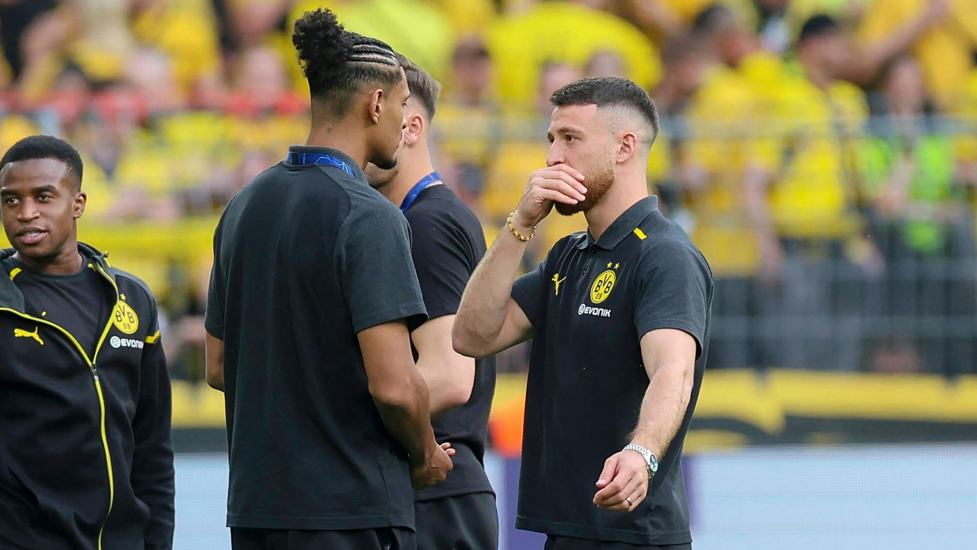 Sébastien Haller und Salih Özcan unterhalten sich bei der Platzbegehung, im Hintergrund steht Youssoufa Moukoko.
