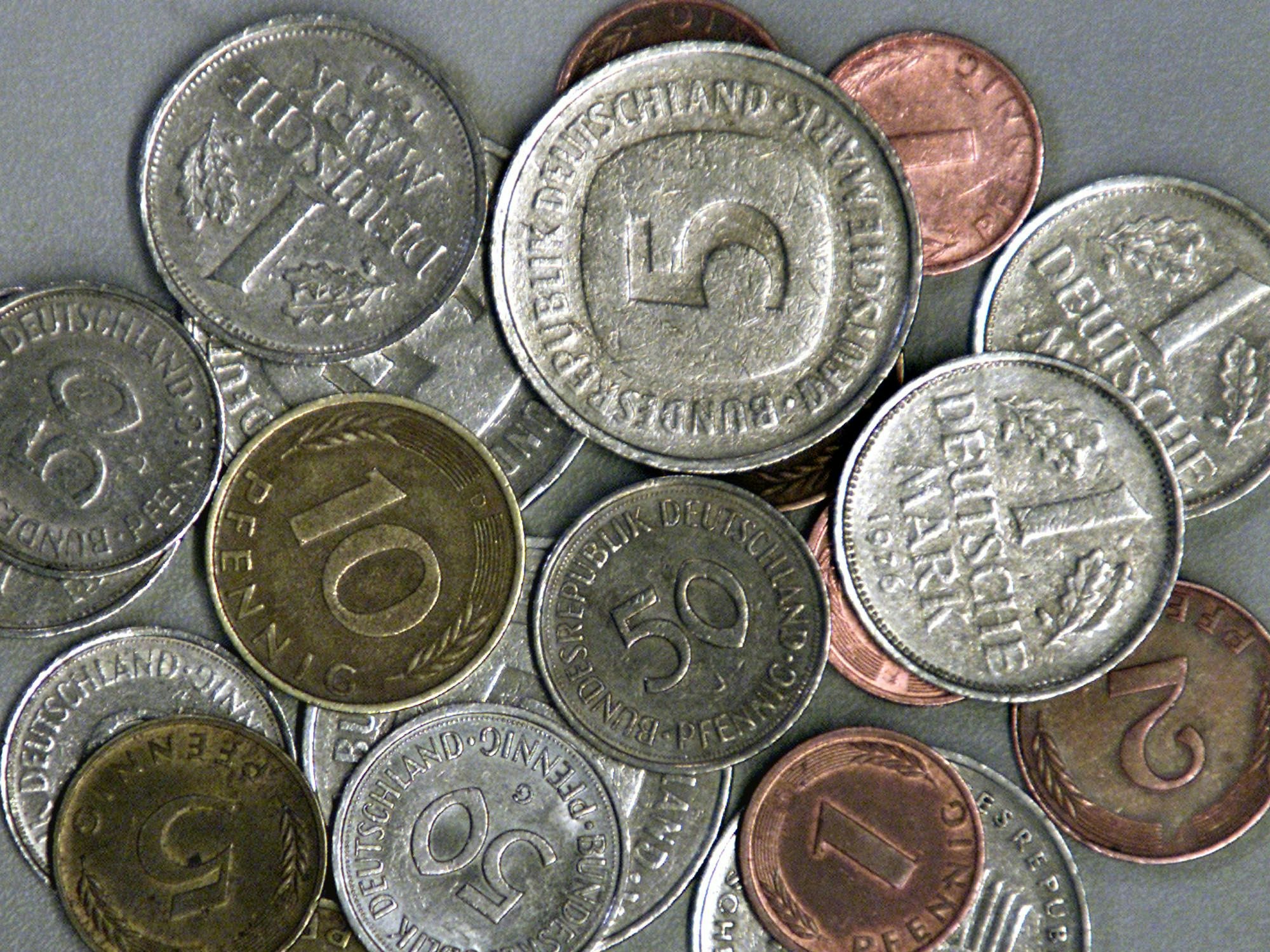 D-Mark-Münzen liegen auf einem Tisch.