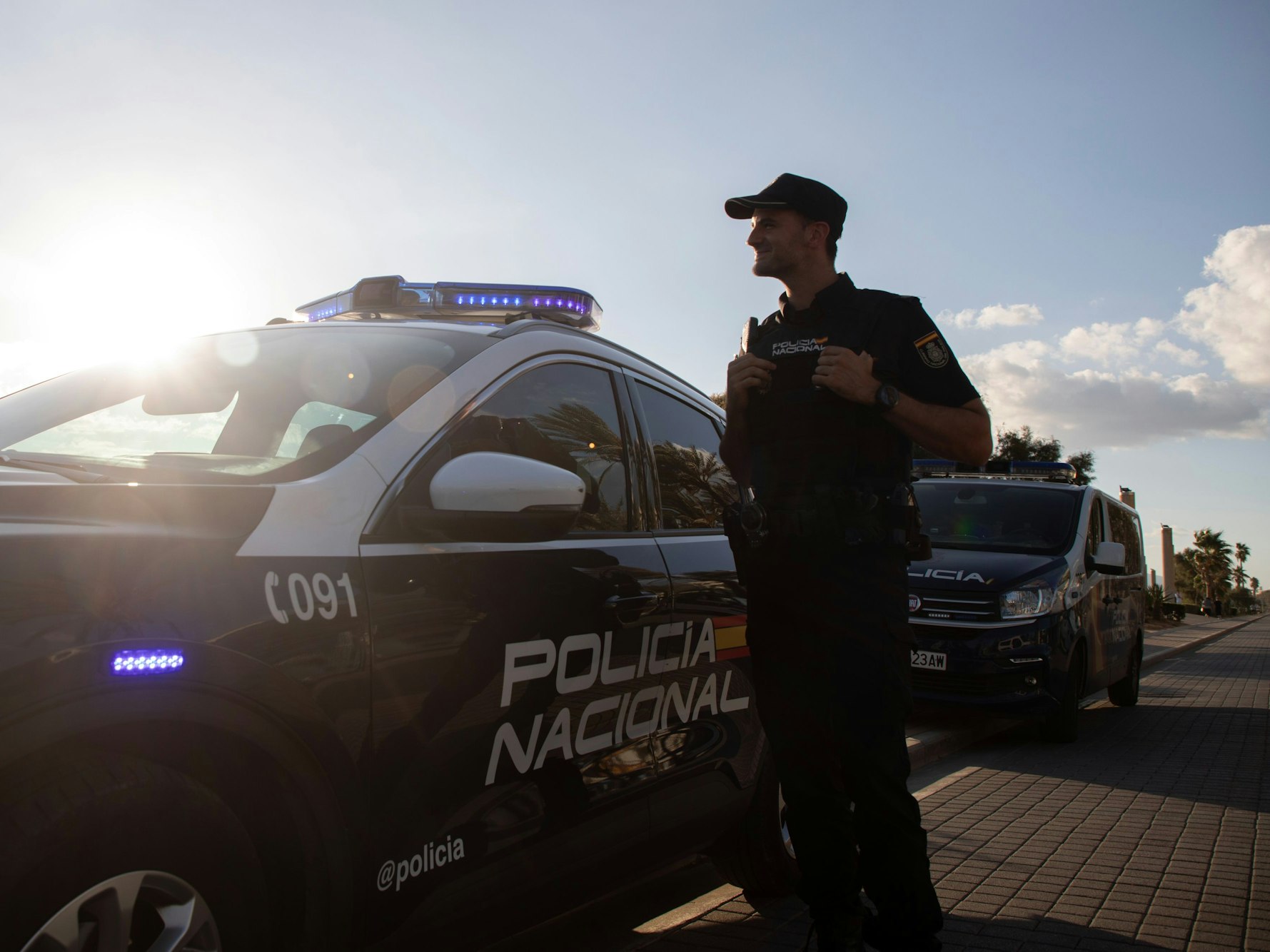 Ein Polizist der spanischen Policia Nacional steht neben seinem Fahrzeug.
