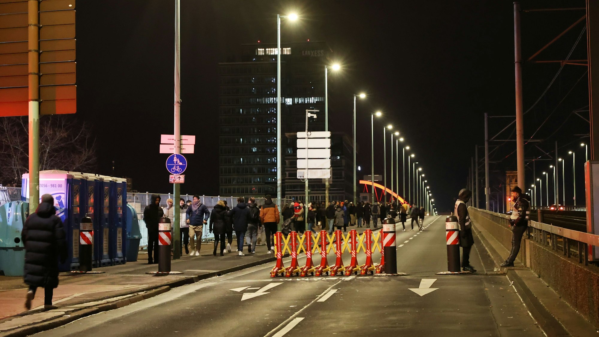 Menschen laufen über eine Brücke, auf der eine Fahrbahn gesperrt wurde.