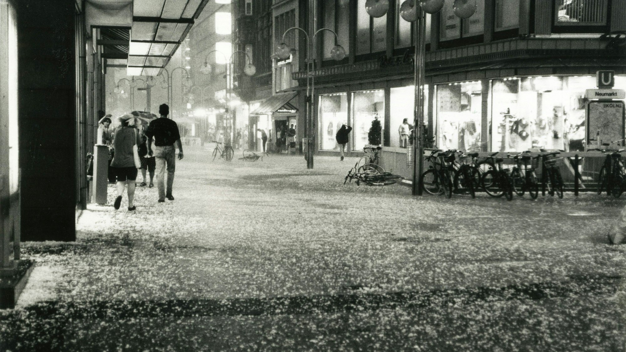 Es ist dunkel, dicke Hagelkörner prasseln nieder, die Menschen flüchten sich unter Vordächer.