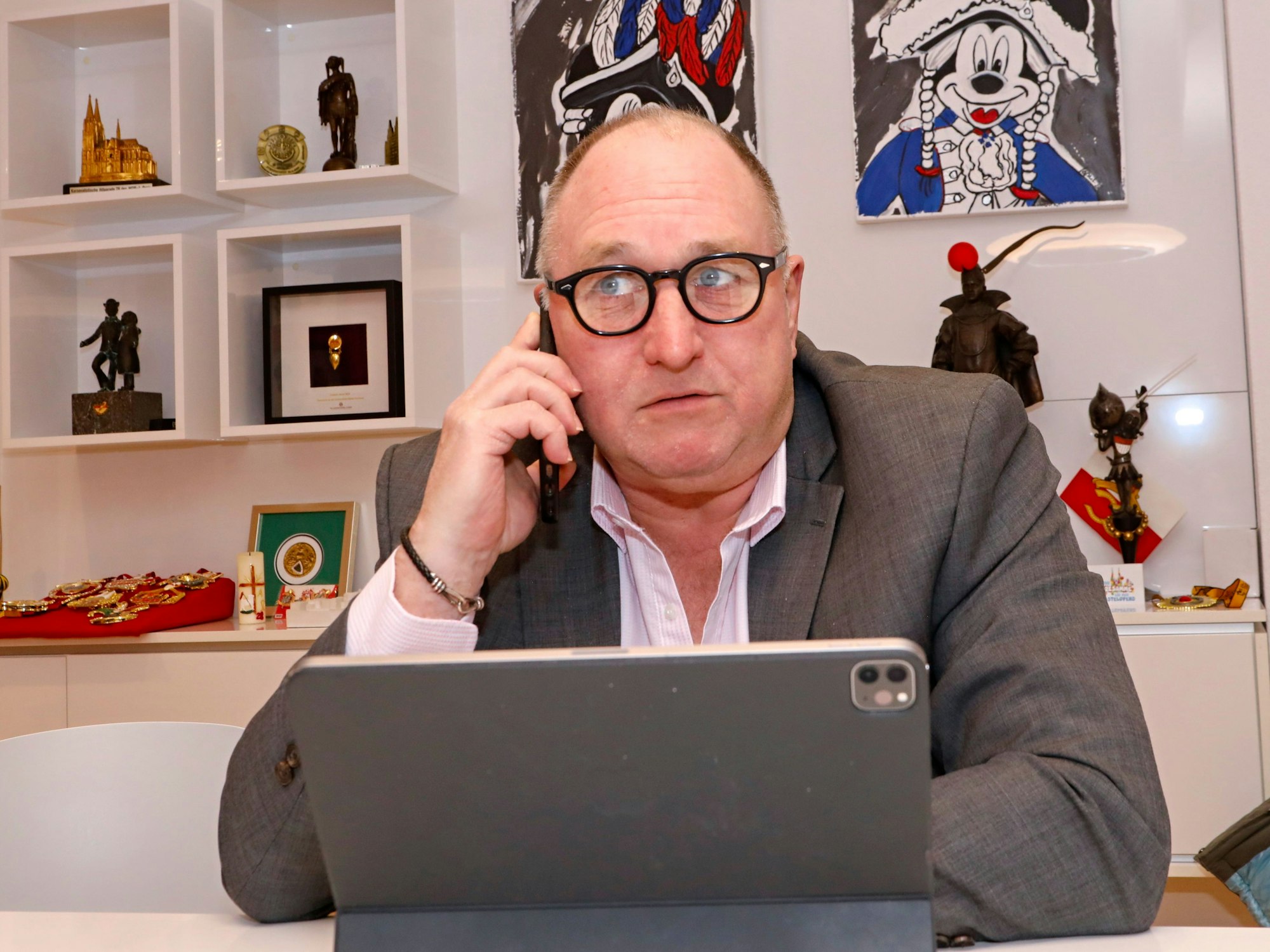 Ralf Schlegelmilch sitzt am Tablet und telefoniert.