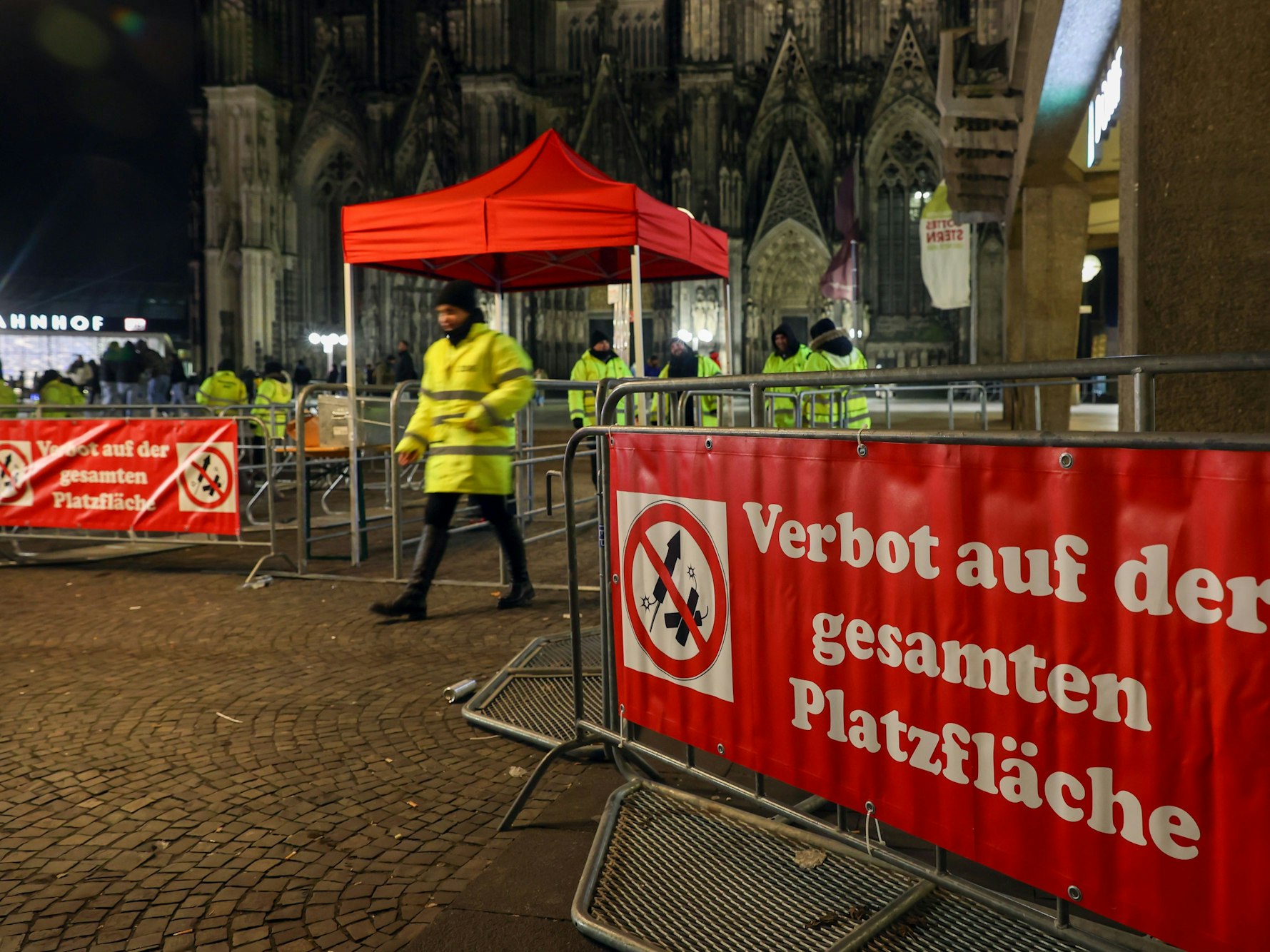 Sperrgitter stehen am Dom, darauf steht „Verbot auf der gesamten Platzfläche“ neben einem Symbol mit einer durchgestrichenen Rakete.