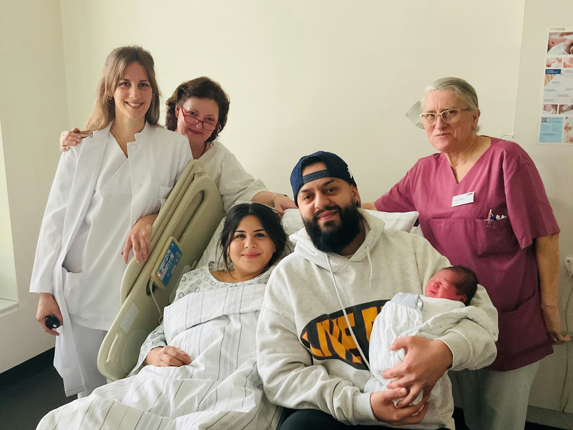 Eine Gruppe mit einem Baby posiert im Krankenhaus für ein Foto.