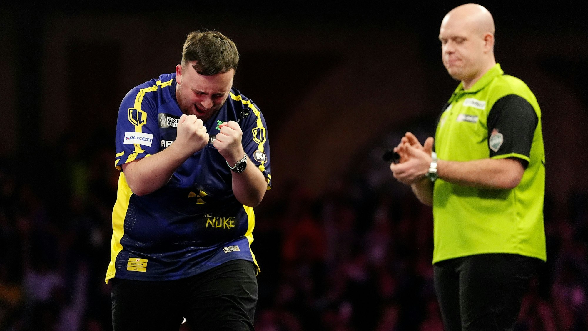 Luke Littler (l) feiert den Sieg im Finale der Paddy Power World Darts Championship gegen Michael van Gerwen (r).