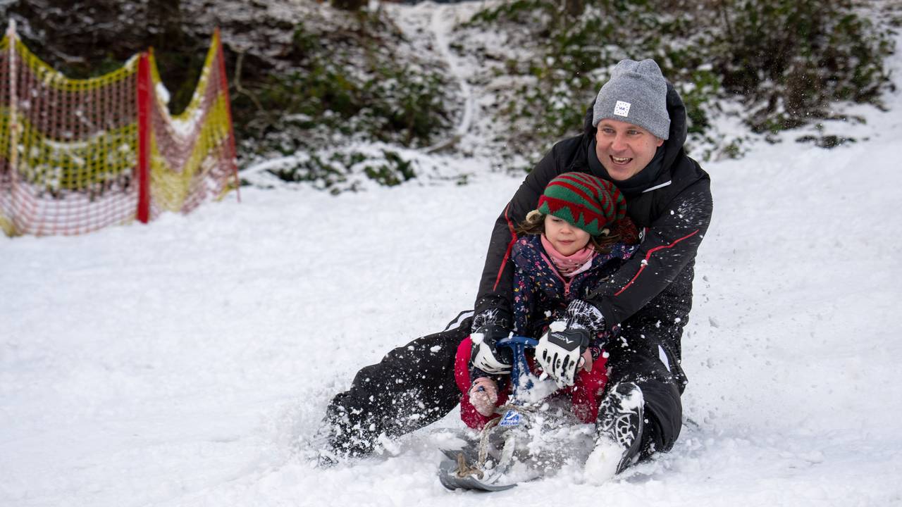 Sascha rodelt mit Tochter Klara Wolfsschlucht den Hang hinab. In der Eifel gab es schon am 2. Januar 2025 Schnee bis in die Niederungen.