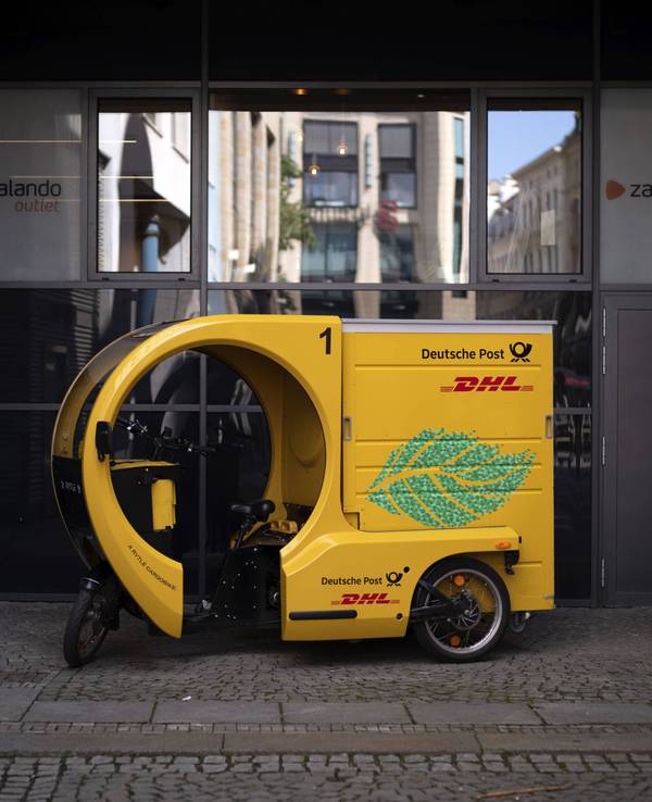 Ein DHL-Wagen steht vor einem Zalando-Geschäft in Leipzig.
